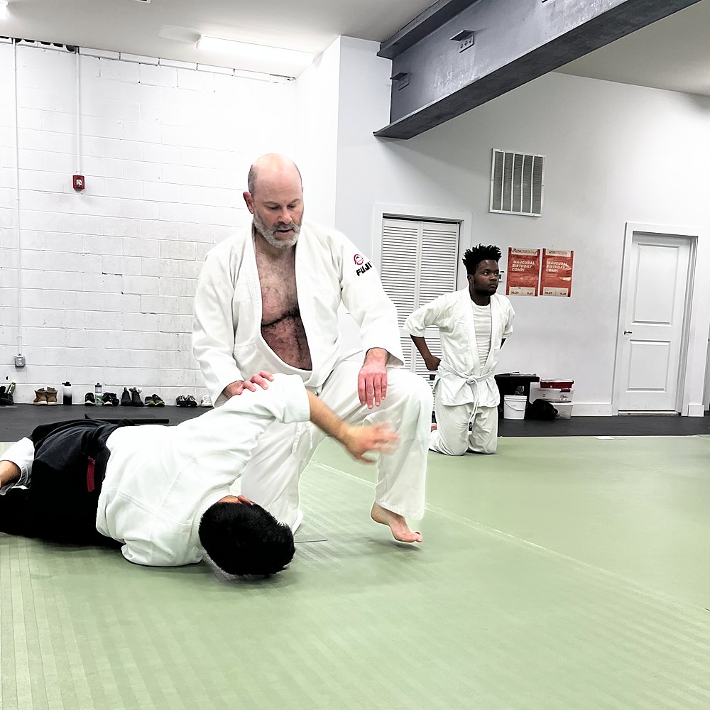 An older student pinning his partner face-down on the mat