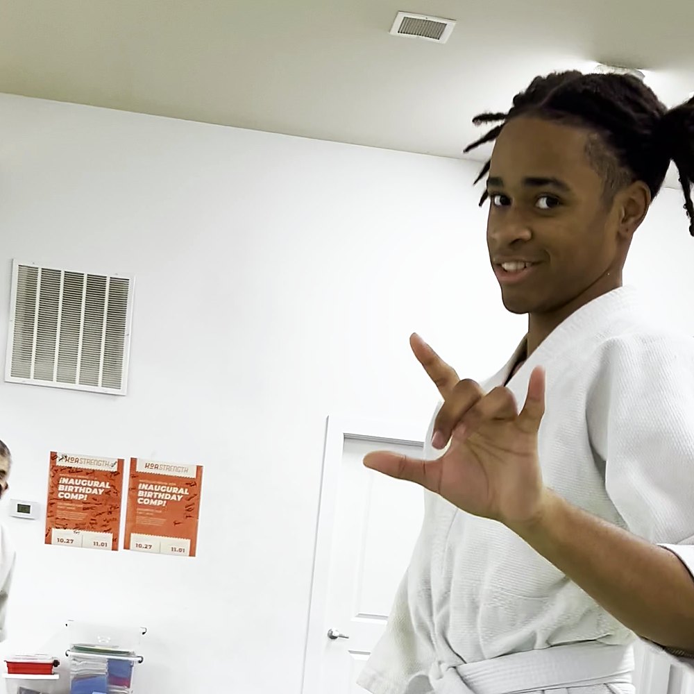 A teenager in a black T-shirt working a technique on an older partner